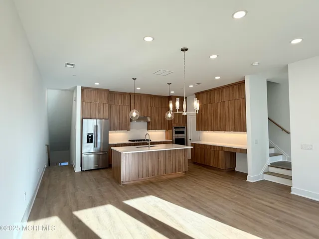 a kitchen with stainless steel appliances a sink a stove a refrigerator and cabinets