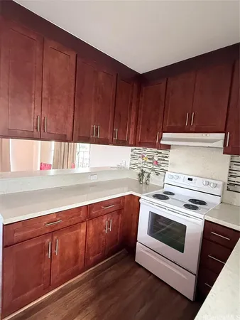 a kitchen with granite countertop wooden cabinets and white appliances