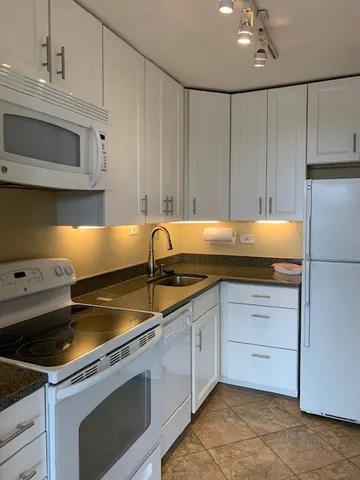 a kitchen with granite countertop a sink and cabinets