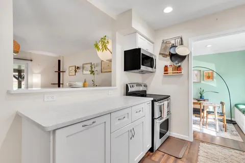 a kitchen with kitchen island white cabinets and stainless steel appliances