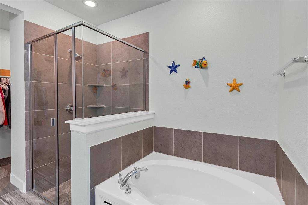7500 Foxgrass Place Fort Worth, TX 76123 - Photo 14 of 29 a bathroom with a bathtub and a shower