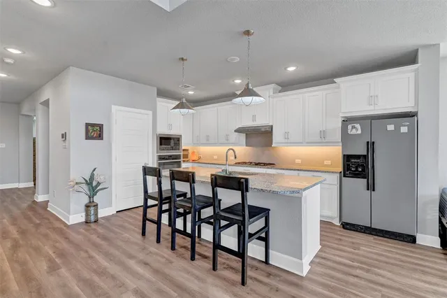 a kitchen with stainless steel appliances granite countertop a sink stove and refrigerator