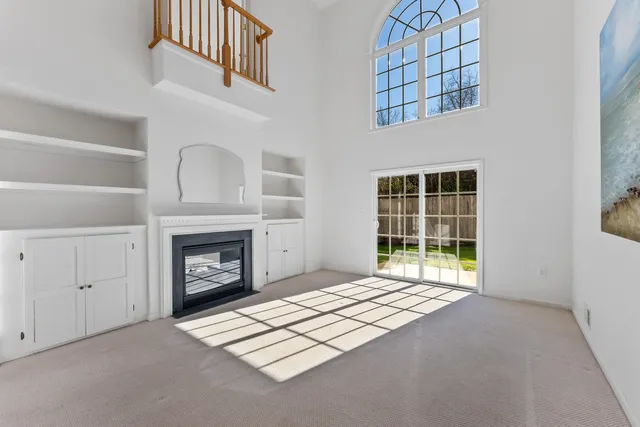 a view of an empty room with a fireplace and a window