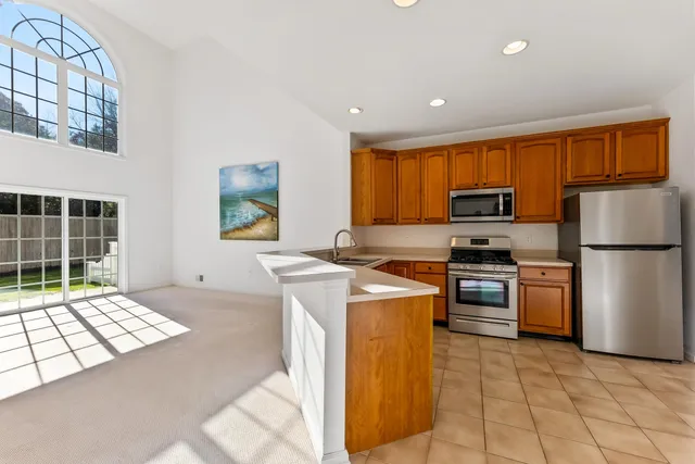 a kitchen with stainless steel appliances granite countertop a refrigerator stove top oven and sink