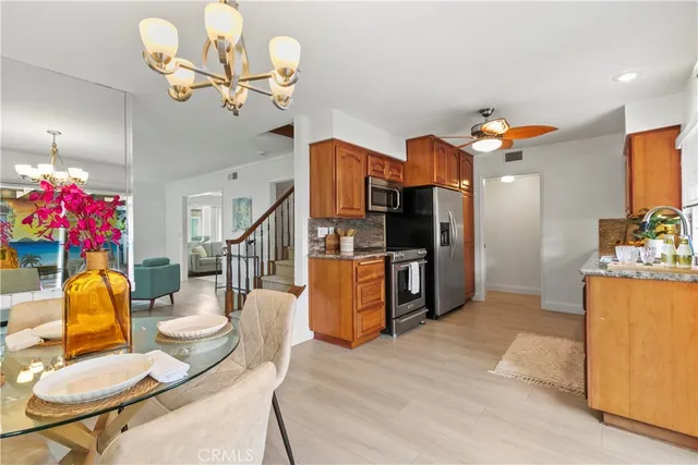 a living room with furniture kitchen view and a chandelier