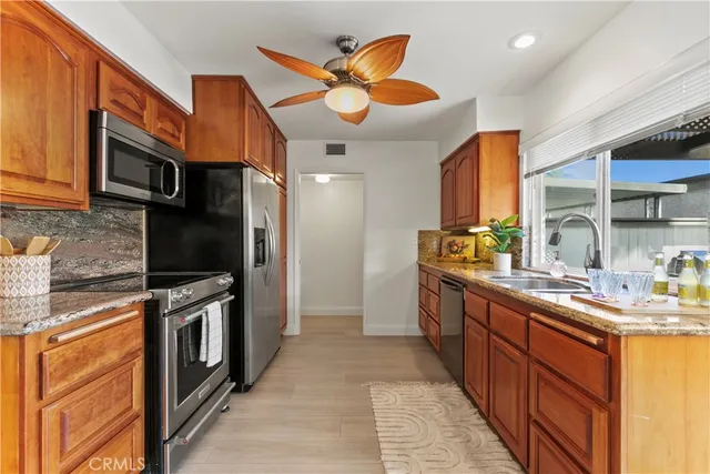 a kitchen with stainless steel appliances granite countertop a stove a sink and a microwave