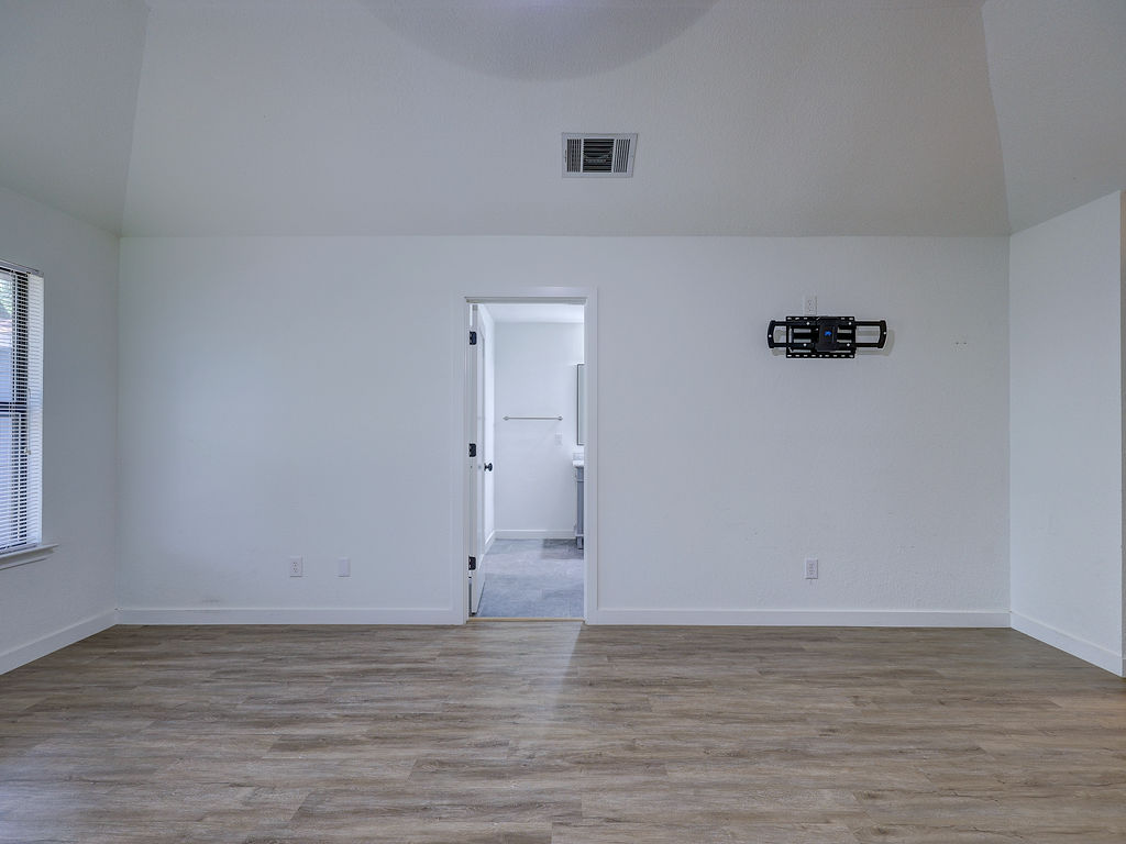 5842 Secrest Drive Austin, TX 78759 - Photo 21 of 40 A generously sized bedroom with vaulted ceilings and durable wood-look flooring.