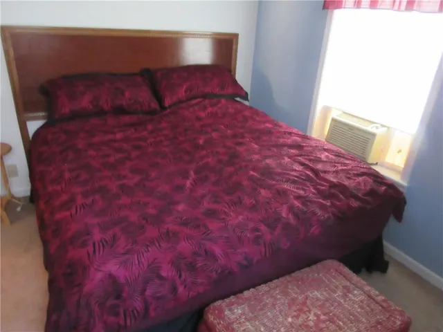 a large bed sitting in a bedroom next to a window
