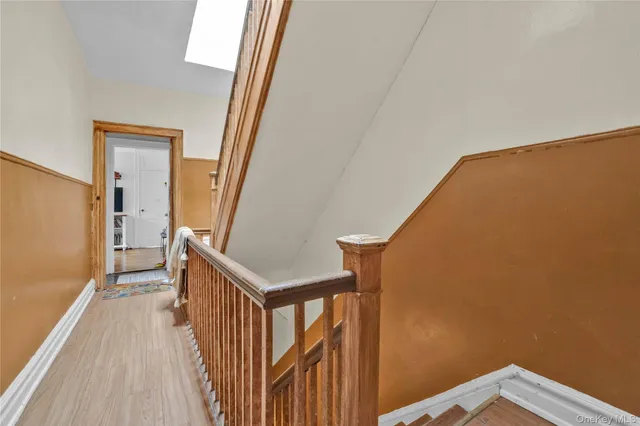 a view of a hallway with wooden floor and staircase