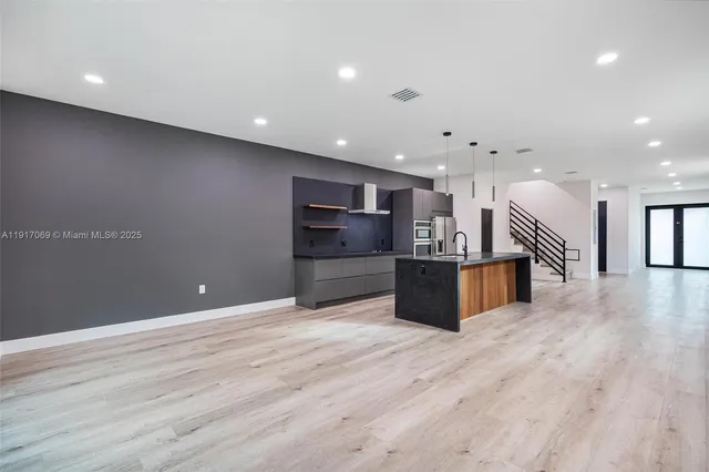 a view of a kitchen with a sink and an empty room