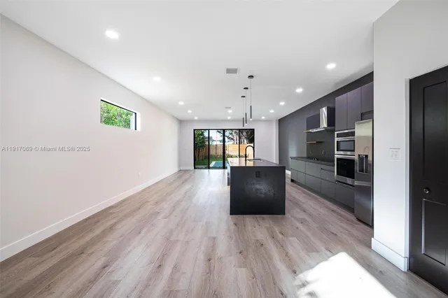 a view of kitchen with microwave and refrigerator