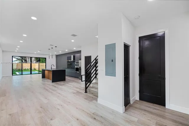 a view of an empty room with wooden floor and a cabinet