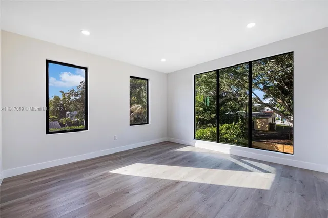 a view of an empty room with wooden floor
