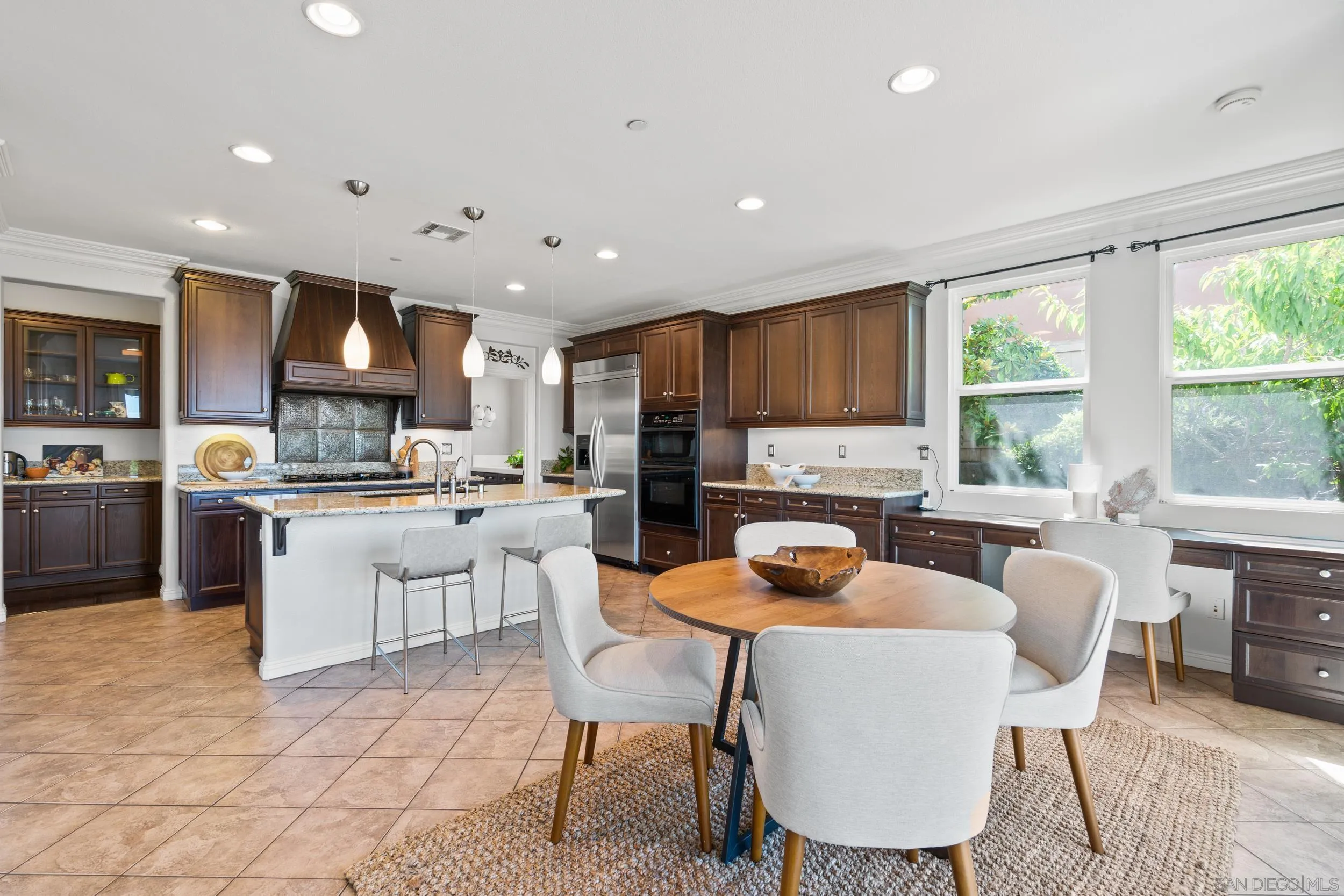 16174 Cayenne Ridge Road San Diego, CA 92127 - Photo 23 of 52 a kitchen with a table chairs refrigerator and cabinets
