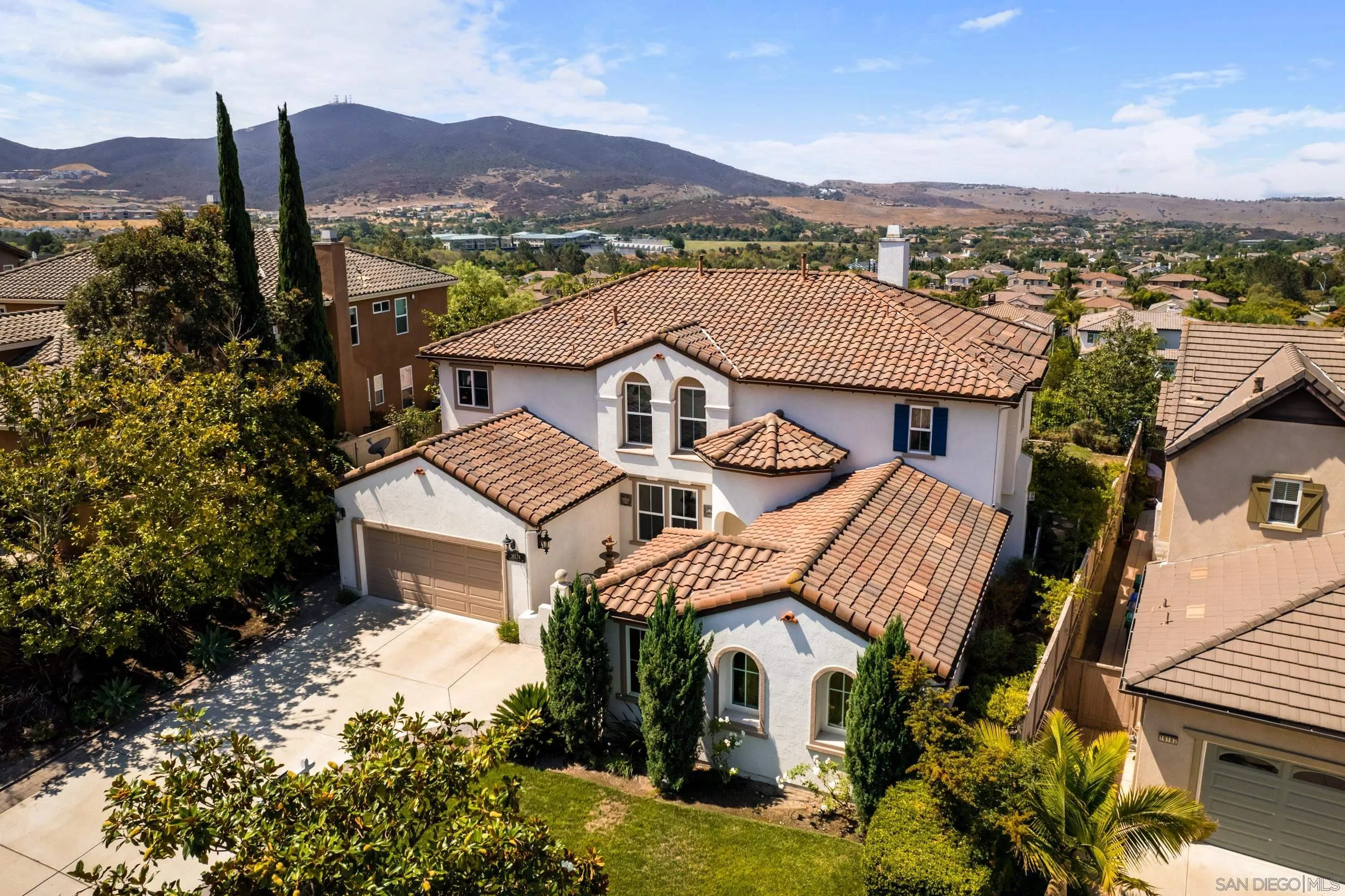 16174 Cayenne Ridge Road San Diego, CA 92127 - Photo 49 of 52 a front view of a house with a yard and mountain view in back