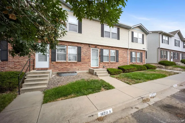 a front view of a house with a yard and potted plants