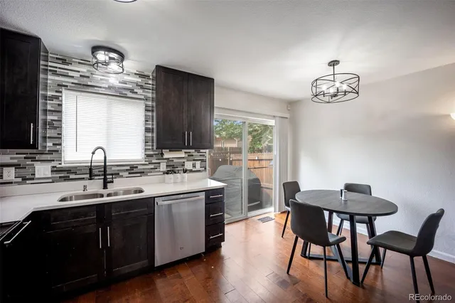a kitchen with a table chairs sink and cabinets