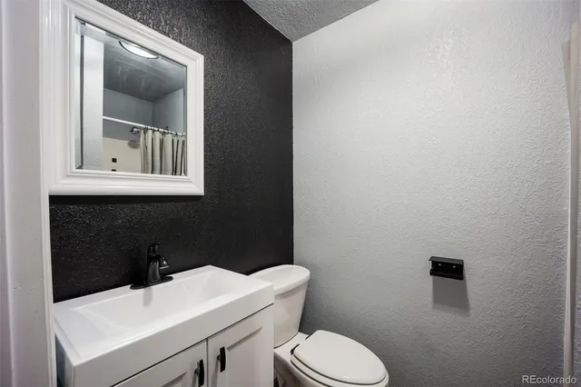 a bathroom with a toilet a sink and mirror