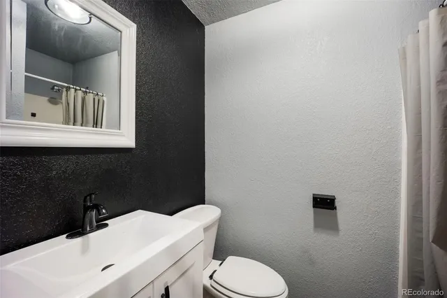 a bathroom with a sink a toilet and mirror