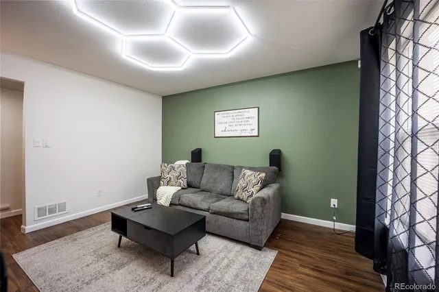 a living room with furniture and a wooden floor