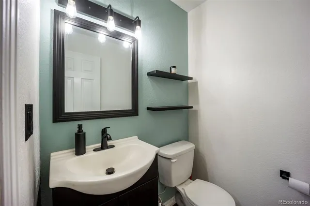 a bathroom with a sink toilet and mirror