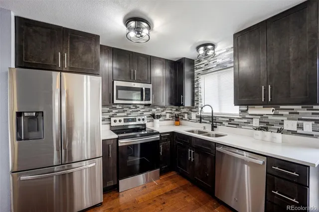 a kitchen with a sink stainless steel appliances a refrigerator and a sink
