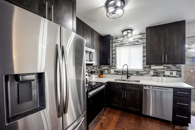 a kitchen with stainless steel appliances a refrigerator a sink a stove and cabinets