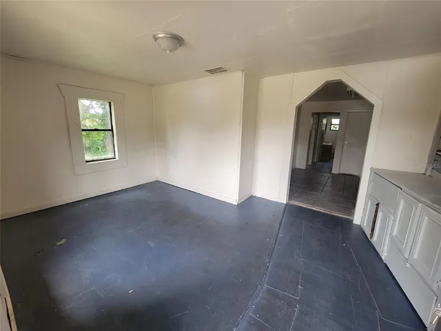 a view of a hallway to a livingroom with wooden floor and a window
