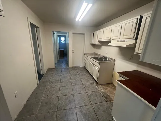 a kitchen with granite countertop a refrigerator and a stove top oven
