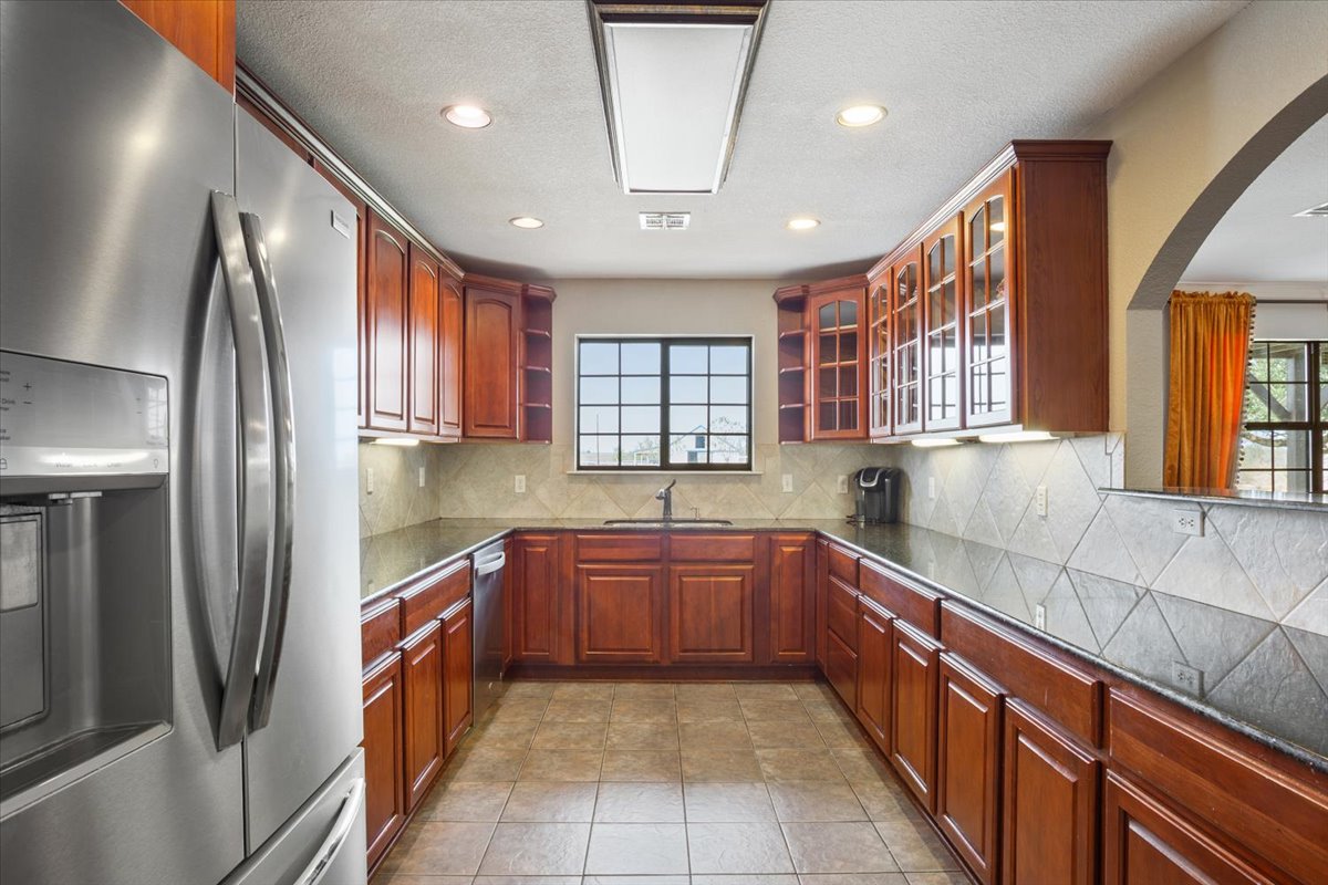 8600 Five Wells Road Rogers, TX 76569 - Photo 12 of 40 a large kitchen with stainless steel appliances granite countertop a refrigerator and a sink