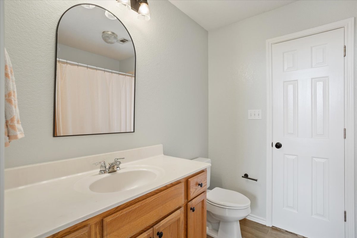 8600 Five Wells Road Rogers, TX 76569 - Photo 23 of 40 a bathroom with a granite countertop sink toilet and a mirror