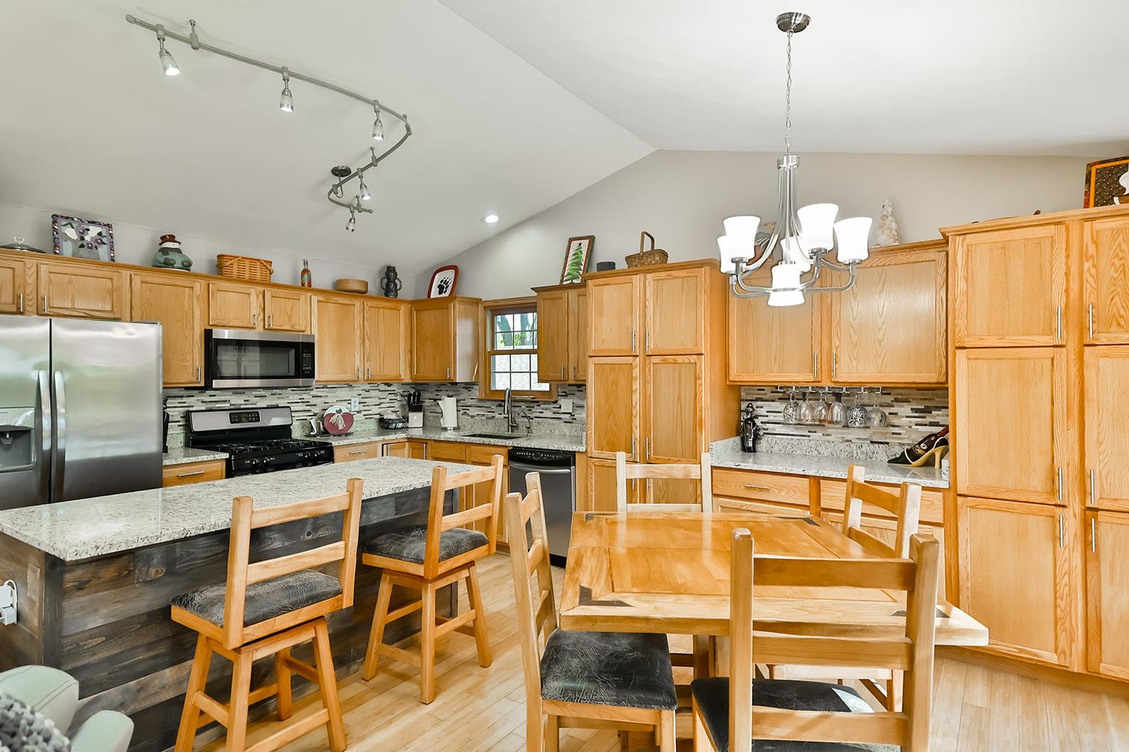 245 Rochester Road Northeast Poplar Grove, IL 61065 - Photo 8 of 29 a kitchen with stainless steel appliances kitchen island granite countertop a refrigerator a stove a oven and white cabinets with wooden floor