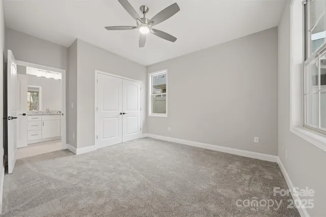 an empty room with a bathroom and a ceiling fan