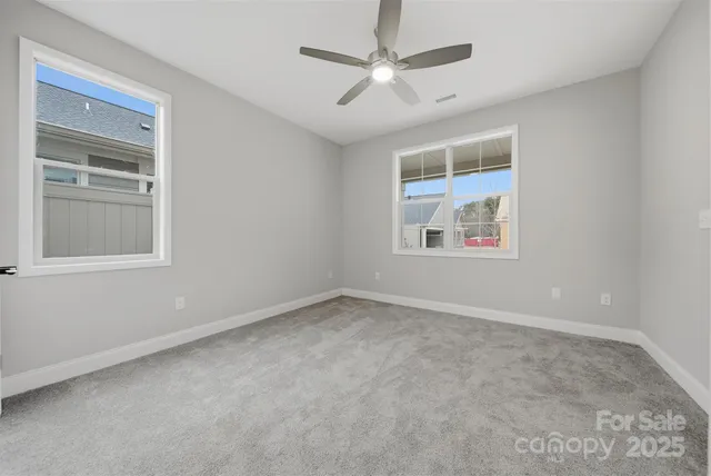 an empty room with a window and a ceiling fan
