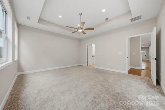 an empty room with fan and windows