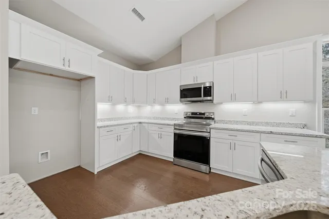 a kitchen with a sink stove and white cabinets