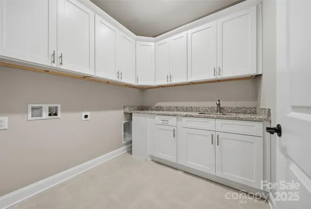 a kitchen with granite countertop white cabinets and a sink