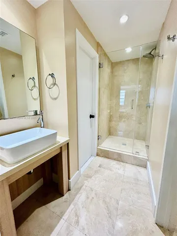 a spacious bathroom with a shower sink and a mirror