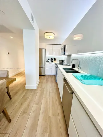 a kitchen with a sink a stove cabinets and a counter top space