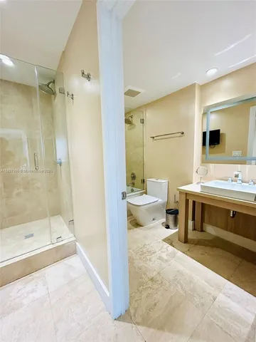 a bathroom with a double vanity sink toilet mirror and bathtub