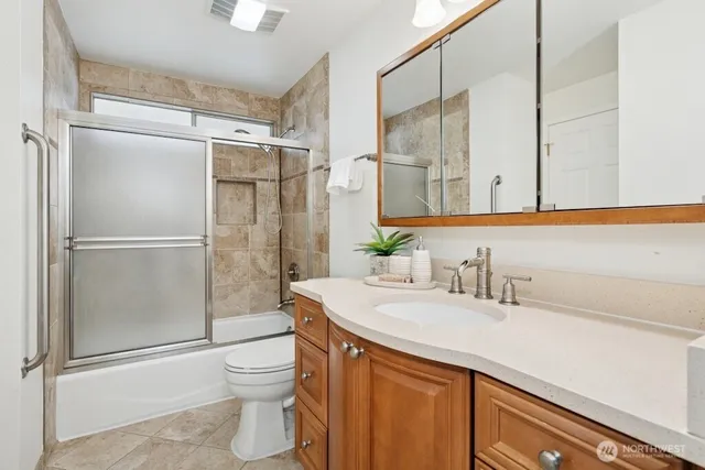 a bathroom with a granite countertop sink toilet and shower