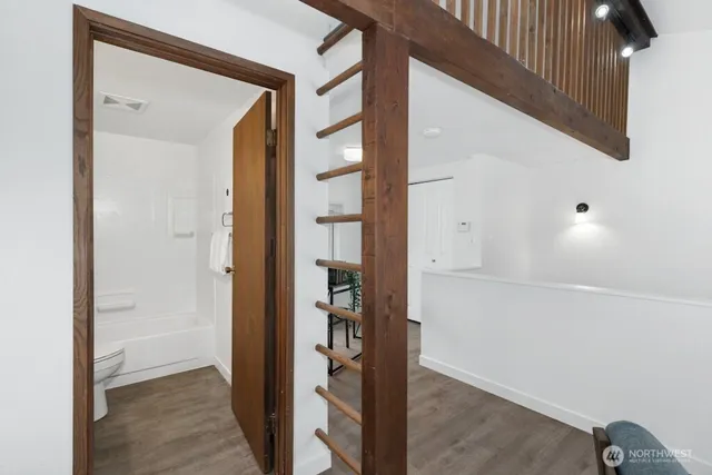 a view of a hallway with closet and wooden floor