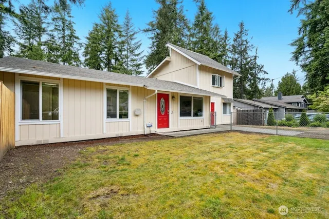a front view of house with yard and trees in the background
