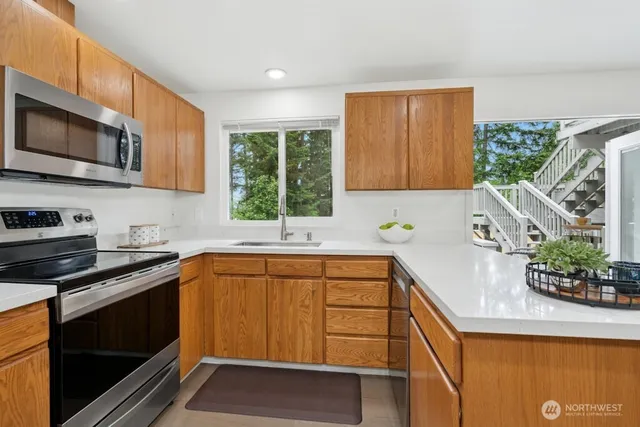 a kitchen that has a sink and a stove top oven