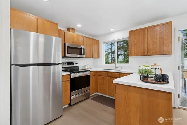 a kitchen with stainless steel appliances granite countertop a refrigerator stove a sink and a microwave