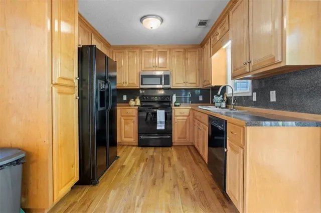 a kitchen with granite countertop cabinets stainless steel appliances and a sink
