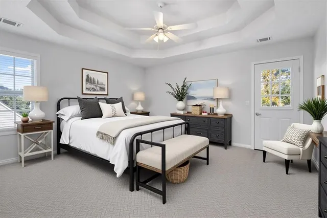 an empty room with a chandelier fan and windows