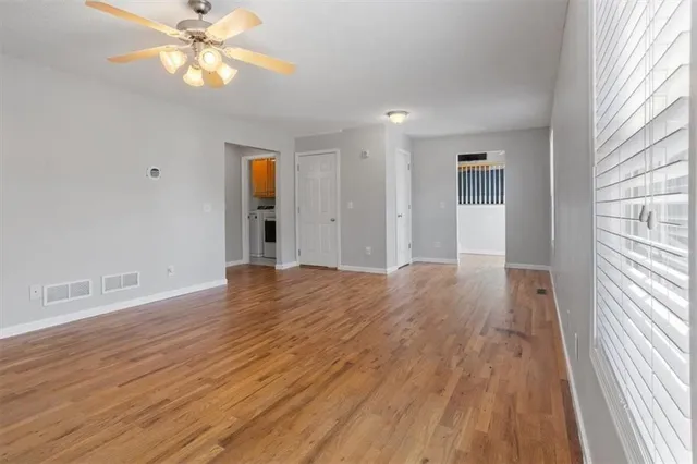 an empty room with a window and a fan