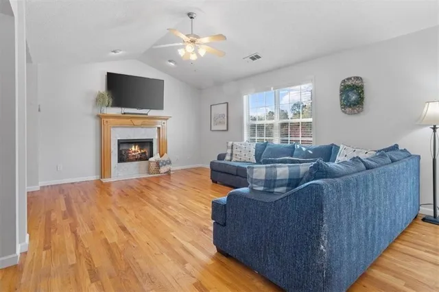 a living room with furniture a fireplace and a flat screen tv