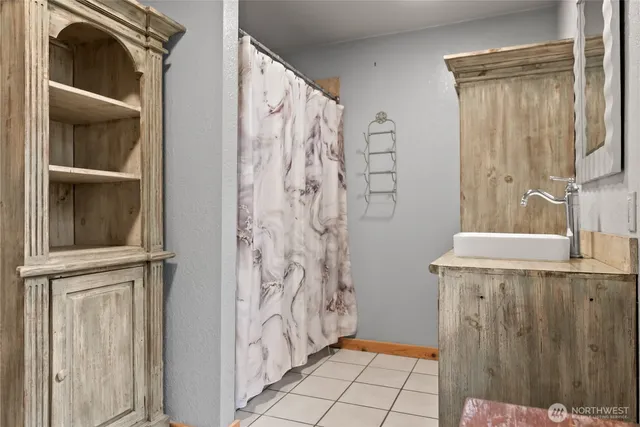 a view of a bathroom with mirror and shower